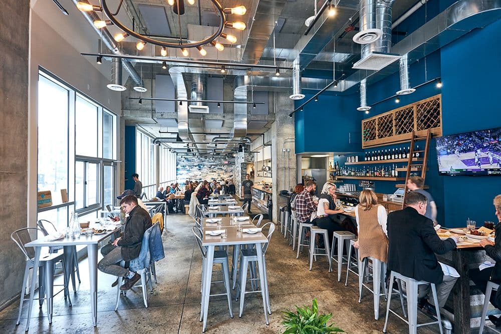 Guests dining in the warm industrial dining room at Crown Republic Gastropub, downtown Cincinnati