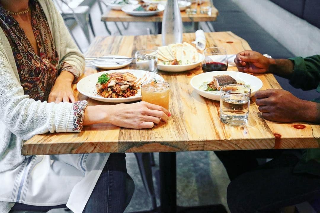 Guests sharing dishes and drinks at a table at Crown Republic Gastropub